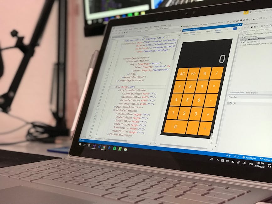 A modern laptop with a silver body and black keyboard is placed on a wooden desk surface, displaying a screen filled with lines of code or text in a light-colored editor window. The laptop's screen is